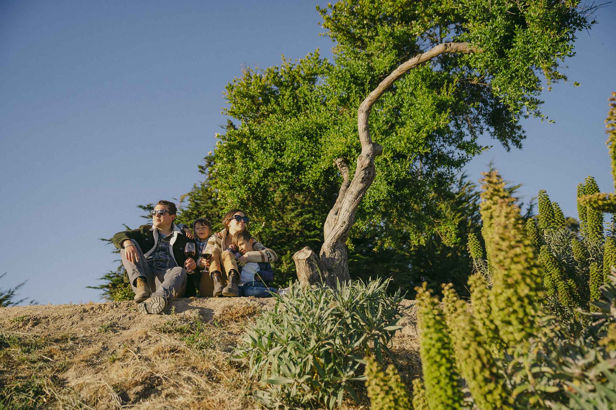 family sitting together on a hill